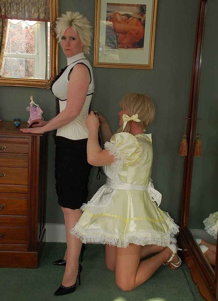 a mistress being zipped up by a sissy maid
