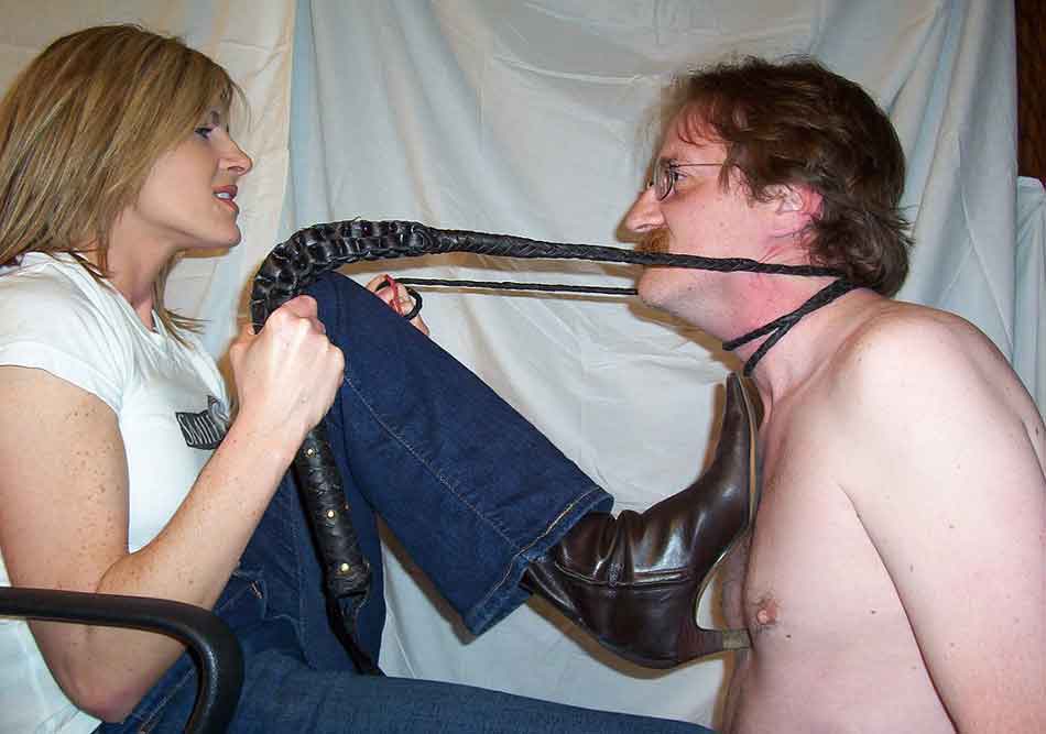 a mistress with leash pulling a sub close heel on chest