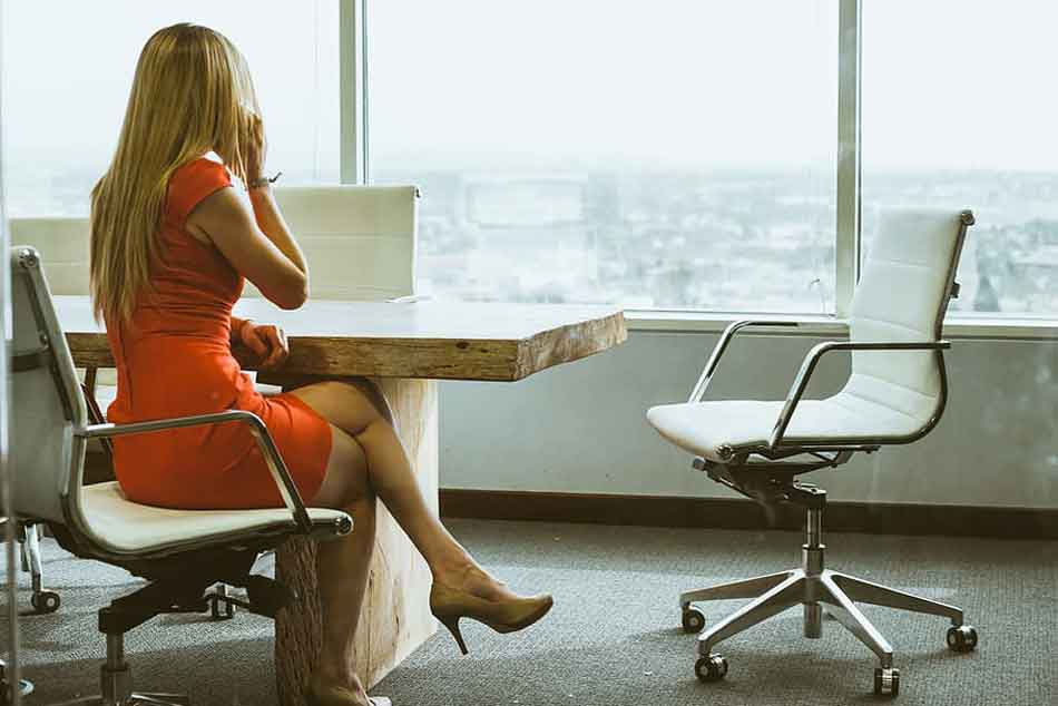 a female dominant in office on phone at desk