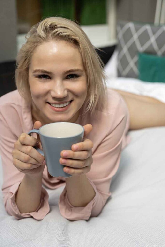 a mistress on the bed with a mug of coffee