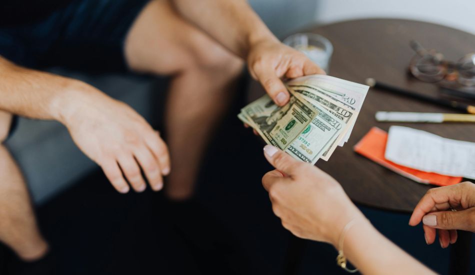 a man handing cash to a woman