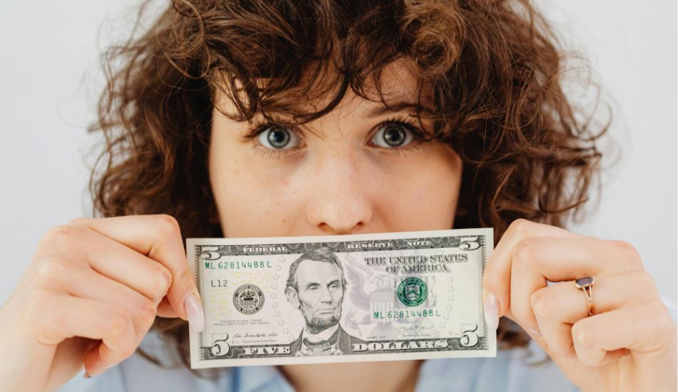 a woman holding a dollar bill